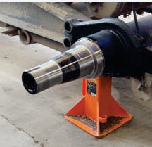 Tapered trailer spindle after replacement, fitted to the axle on a stand