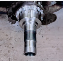 Drive axle bolt-on spindle after replacement, showing clean machined bearing surfaces