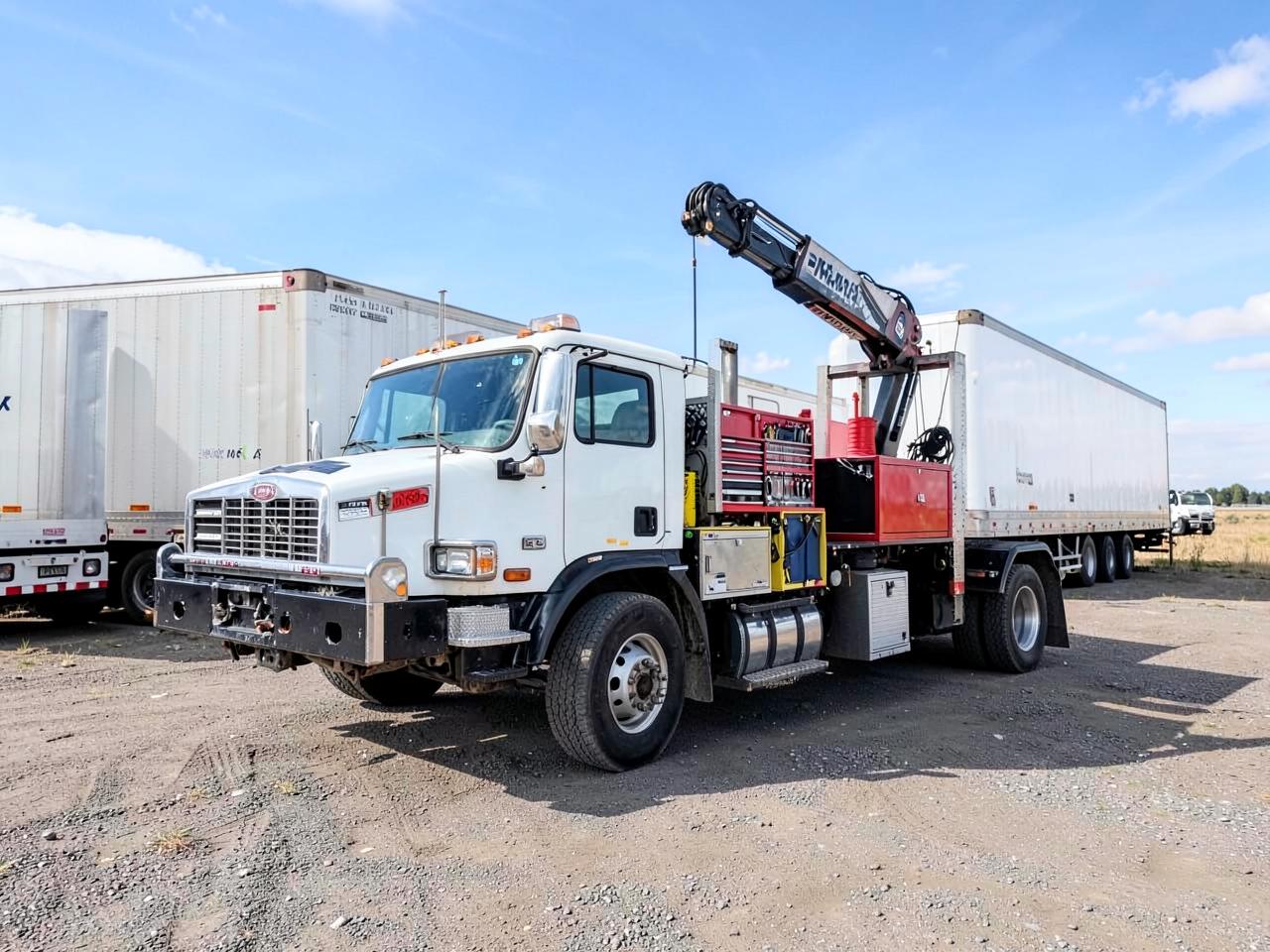 Mobile service truck parked beside a commercial trailer at a fleet yard